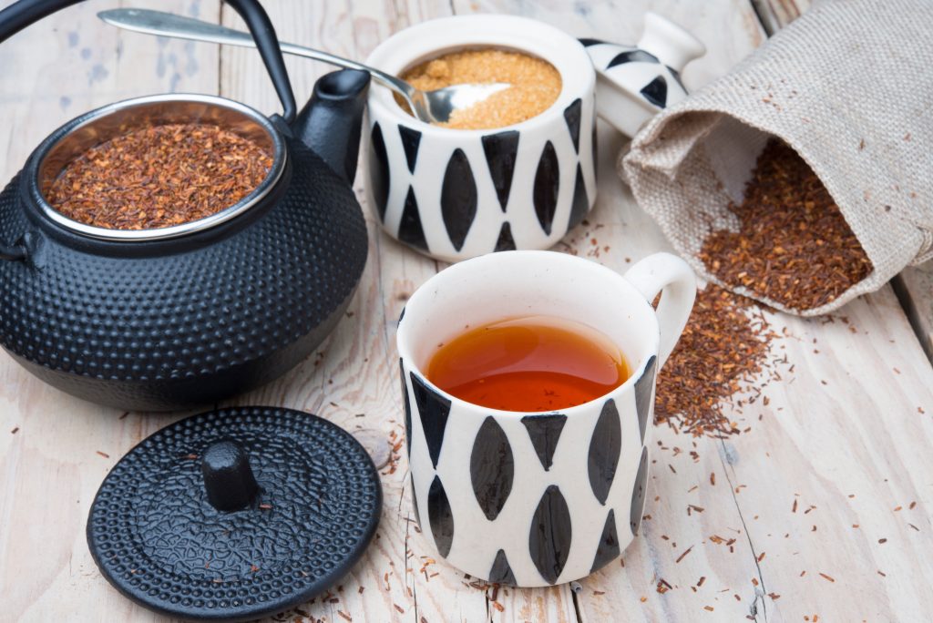 A mug of tea and a kettle steeping