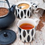 A mug of tea and a kettle steeping